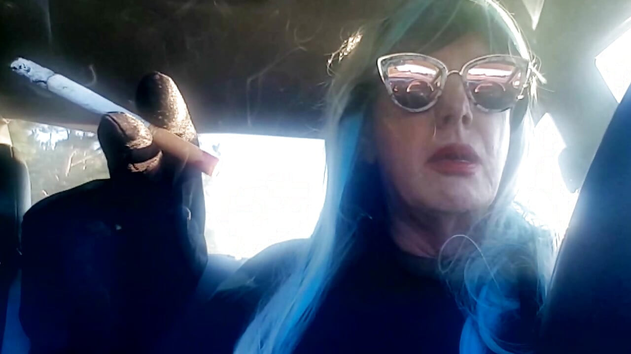 MATURE CD SMOKING & DRIVING WITH A MB100 CIGARETTE IN HER GLOVED HAND