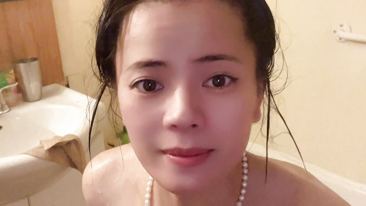 小柄な花が浴槽で裸で、シャワーの時間、全身濡れ