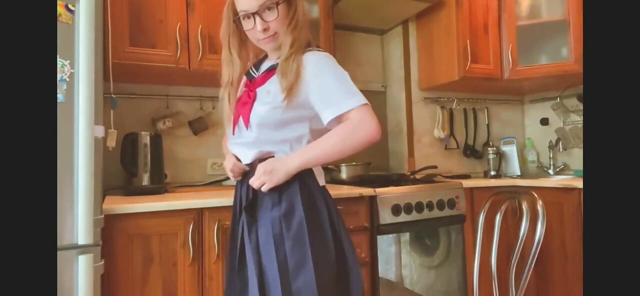 Νεαρή καλλονή με ιαπωνική στολή κολεγίου αυνανίζεται στην κουζίνα και συνομιλεί μαζί σας
