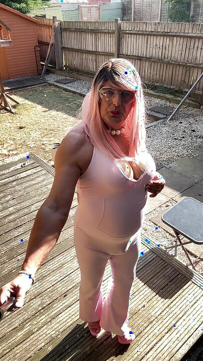 Crossdresser kellycd2022 u ružičastom kombinezonu i štiklama