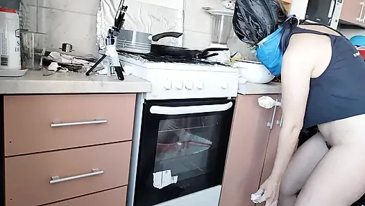 Sexy ehefrau bereitet das mittagessen nackt in der küche vor.