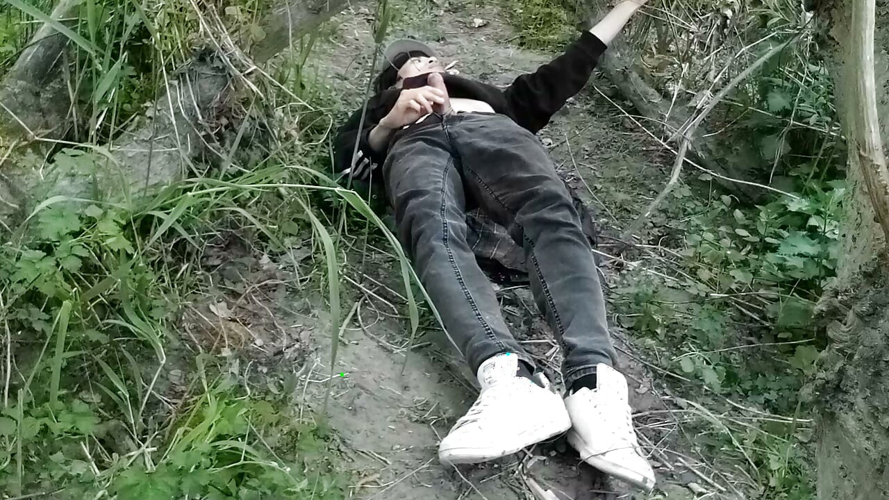 This gay twink sticks his cock through his fly to jerk off outside