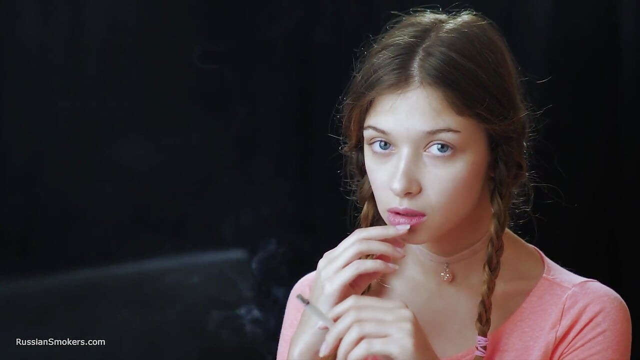 Szexi orosz csábító cigarettázik a tengerparti szellőben