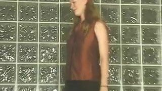 Meisje tegen muur toont haar grote tieten en geschoren poesje
