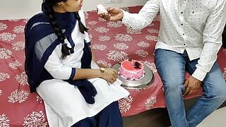 Szkolny przyjaciel Komala kroi ciasto, aby świętować dwa miesiące