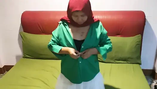 Gadis berjilbab memetik di bawah rok putih