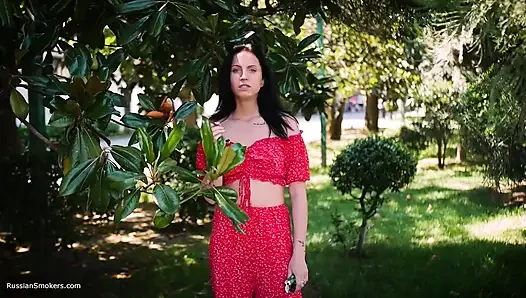 Kırmızı elbiseli ateşli esmer kadın sigara içiyor