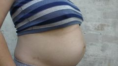 Ehefrau im Freien mit einem riesigen betrügenden schwangeren Bauch - milchiger Mari