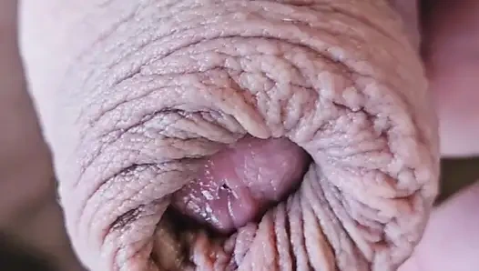 Возбужденный необрезанный мужик играет с длинным предэягом и камшотом на предплечье