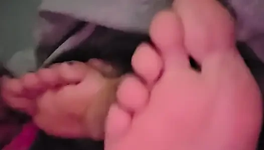 Sucking her toes while she watches a movie