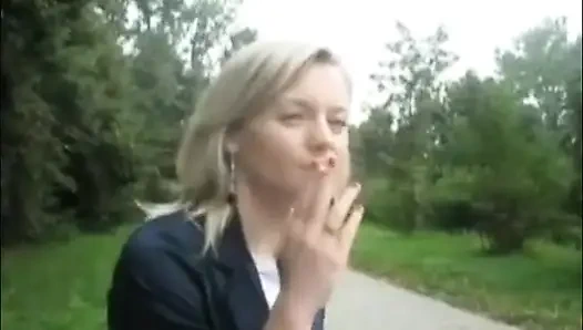 Blonde beauty smoking a cigarette outdoors