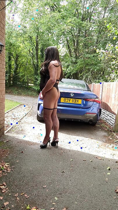 Seksi transvestit kellycd2022 u crnom PVC bodiju i mrežastim čarapama i štiklama