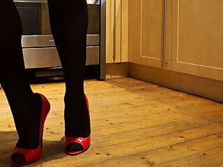 Trong nhà bếp, chuẩn bị bữa ăn với một đôi giày cao gót màu đỏ