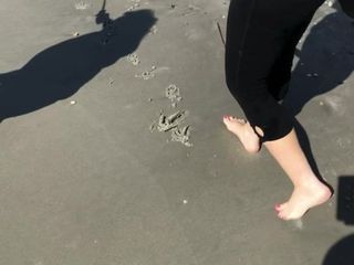 Cunhada em movimento na praia com os pés