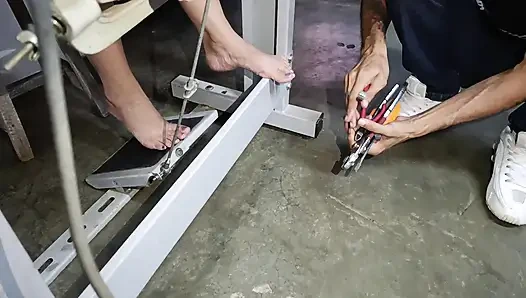 Pumpende nähmaschine tritt in unterwäsche, während ein mann es repariert