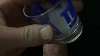 Hung jock cums into shot glass and pours on cock