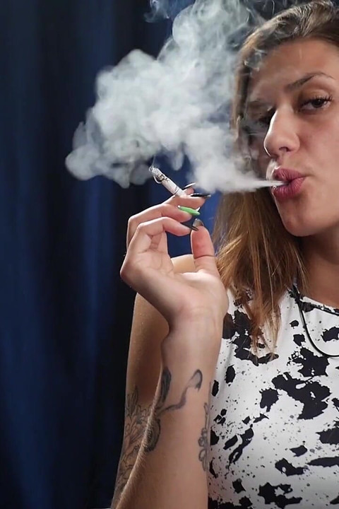 Confident Slim Brunette in a Tight Patterned Dress Enjoying a Slow and Relaxed Smoking Session