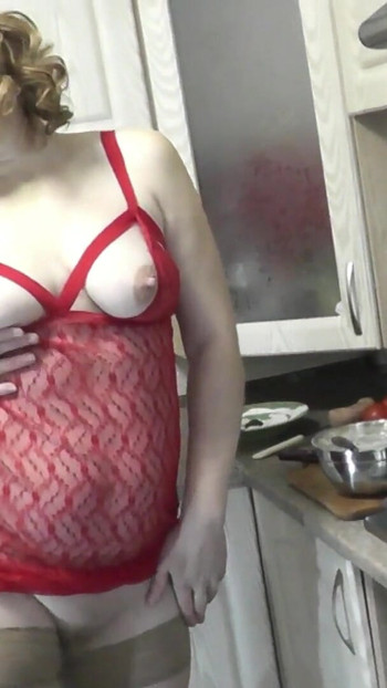 Emotional moment from "Sexy MILF continues cooking in kitchen naked without panties and bra in red transparent negligee."