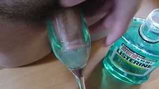 Член опускают в Listerine Fresh Mint для полоскания рта с камшотом