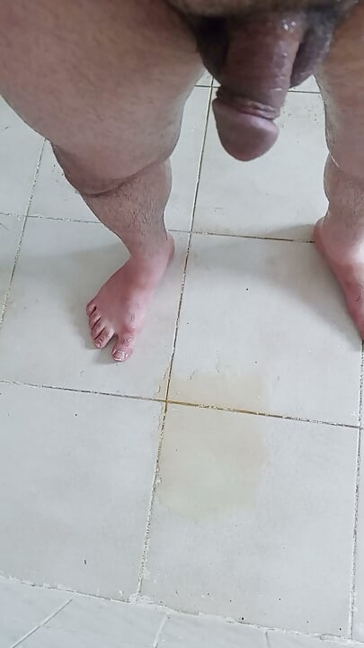 Je pisse sur le sol de la salle de bain, puis je m'assois dans ma pisse et je commence à me masturber