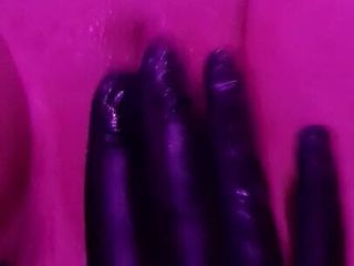 Lateksowe rękawiczki do masażu cipki pod różowym światłem