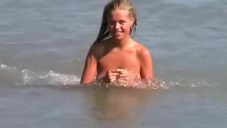 Sexy blondine naakt op het strand