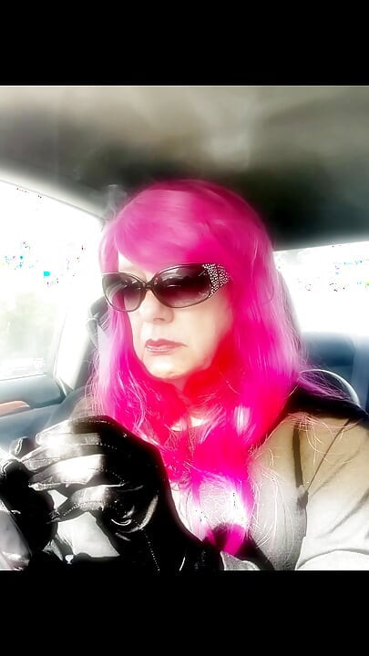 Mrs Roman TG med rosa hår och läderhandskar som röker VS120s Menthol körning CD mogen ladyboy rökning av det högvärdiga