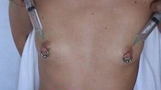 Injeção de soro fisiológico nos mamilos do peito bombeando e vibrando