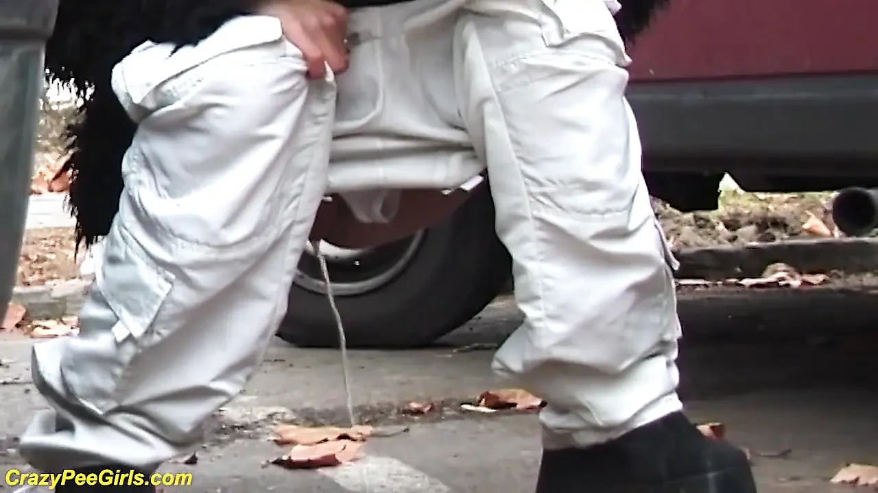 Girl peeing between the cars
