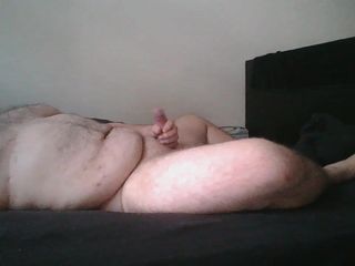 Ragazzo paffuto nudo si masturba sul letto