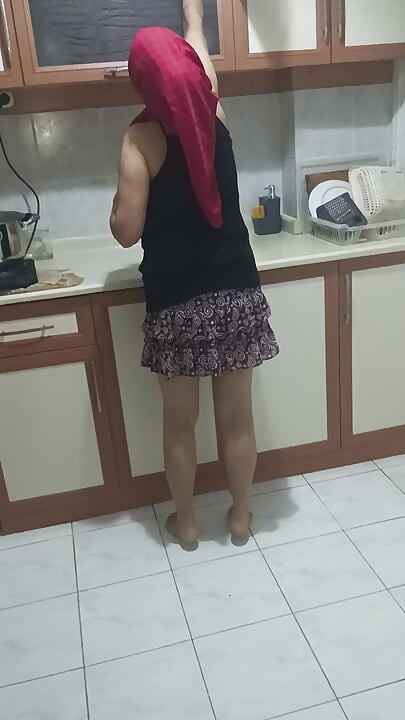 Mature woman in sheer stockings doing housework in the kitchen.