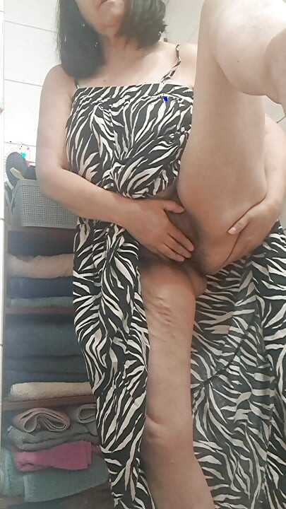 in the bathroom showing what's under her dress to her young lover on camera