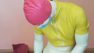 Guy in colorful rubber tries to get in a big latex balloon