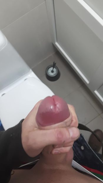 Masturbándose una polla en el baño en el trabajo