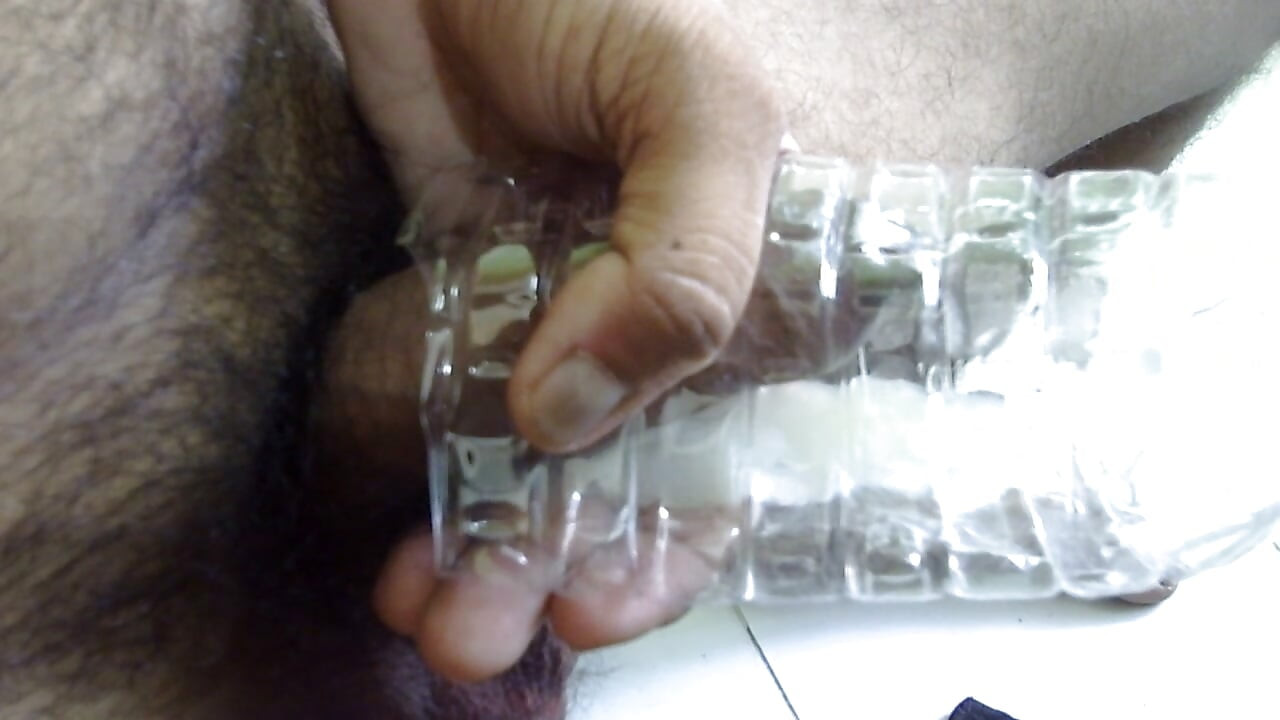 Young Indian man shakes cock and shakes cock in drinking water bottle