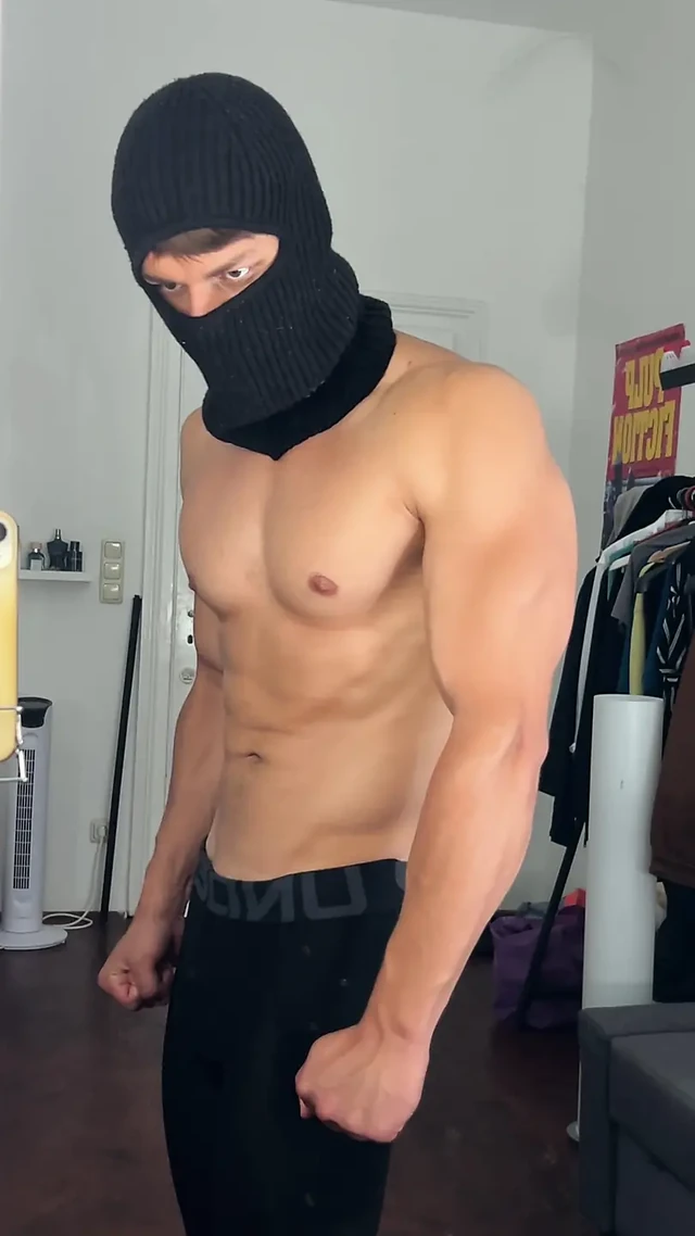 Masked hunk flexing his muscles in a tight leggings