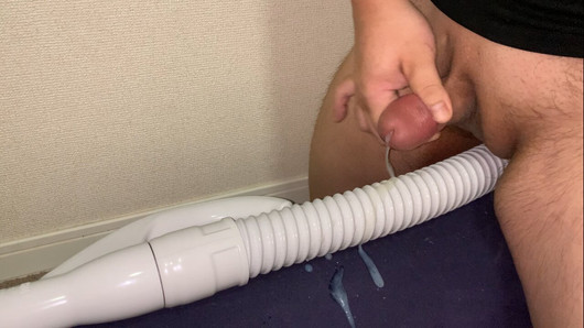 Un gros avec un petit pénis jouit sur le tuyau d'un aspirateur