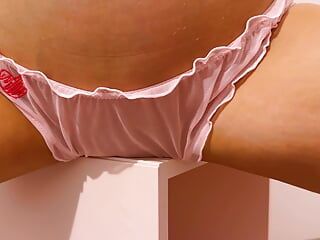 Beauty in pink panties humps pussy against the table corner.