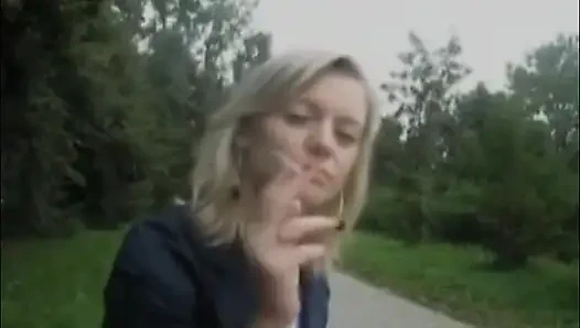 Sarışın güzel kadın açık havada sigara içiyor