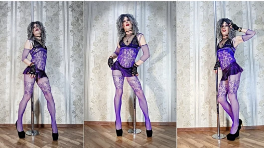 A curly-haired, lustful slut poses in a new purple bodysuit and high heels, wearing a miniskirt and bright makeup.