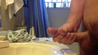 Chico masturbándose en el lavabo del baño