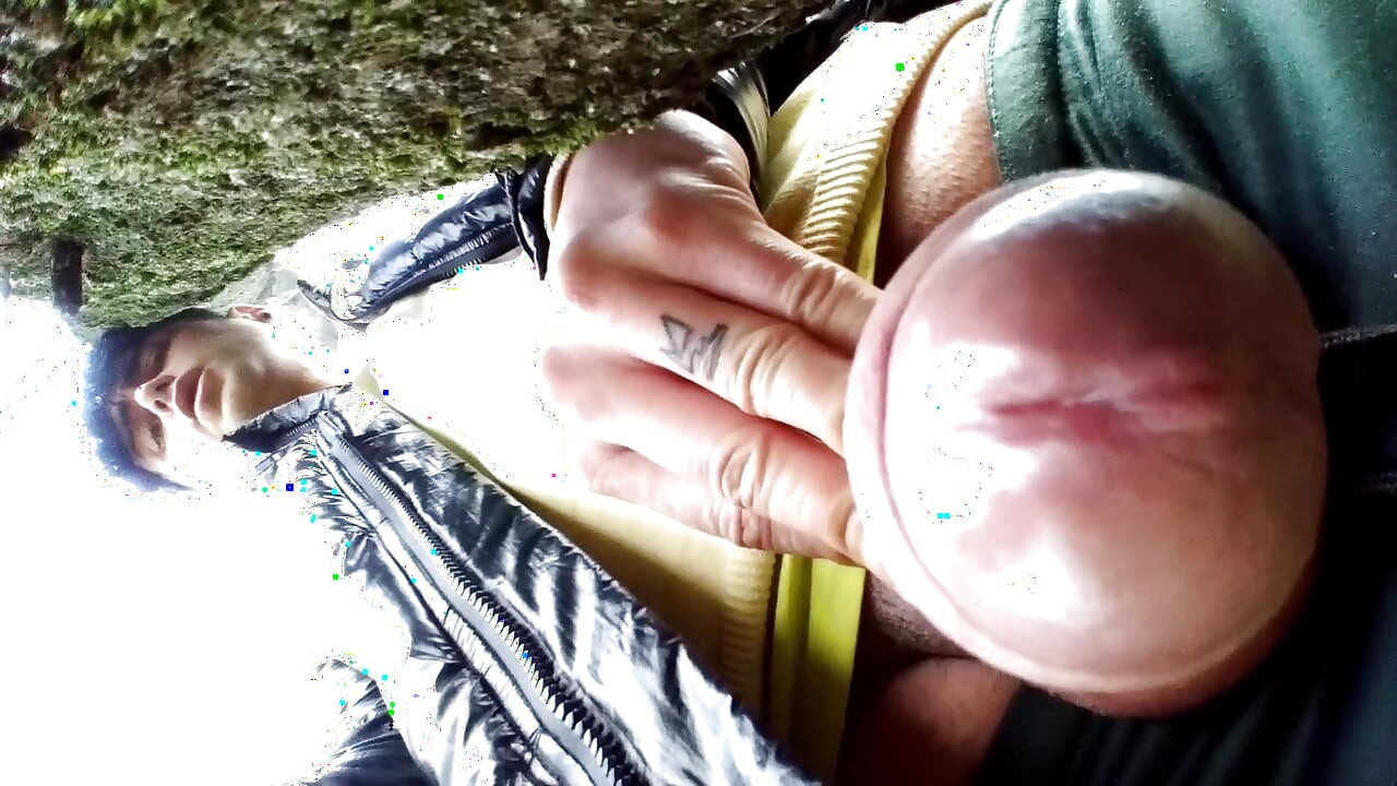 Close-up de porra atrás da árvore no parque e esfregando porra na lente da câmera com glans