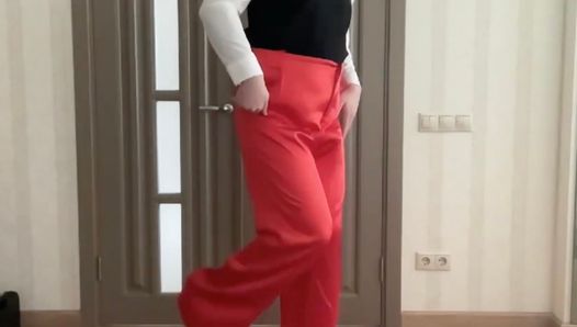 Sissy secrétaire en pantalon large rouge en satin de soie, talons hauts et chemisier de bureau scolaire attend sa femme pour se faire baiser