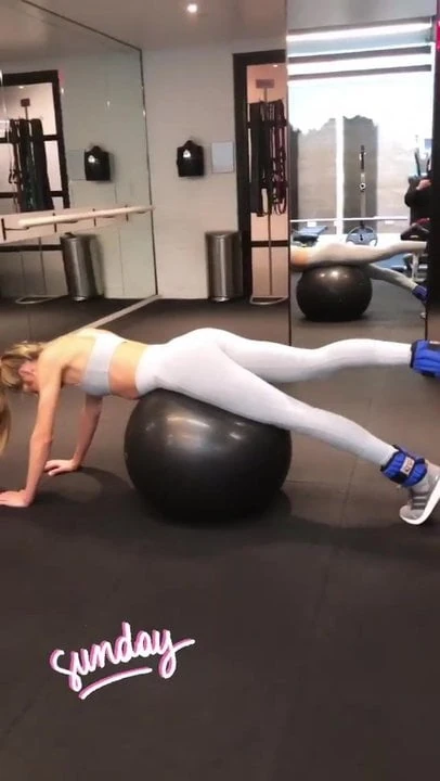 Candice Swanepoel doing stretches on a stability ball