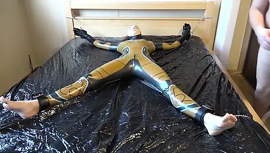 Latex Danielle is attached to the bed and masturbated with the massage vibrator