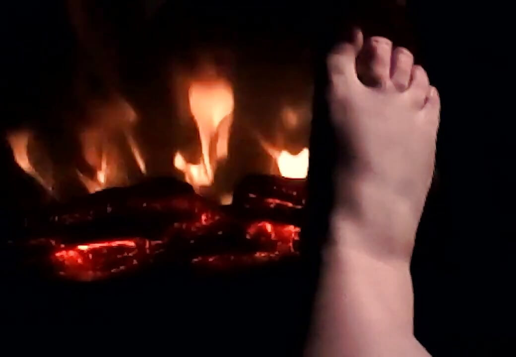 Je réchauffe mes pieds sur le feu pour qu'ils soient chauds et moites pour ta bite et tes couilles