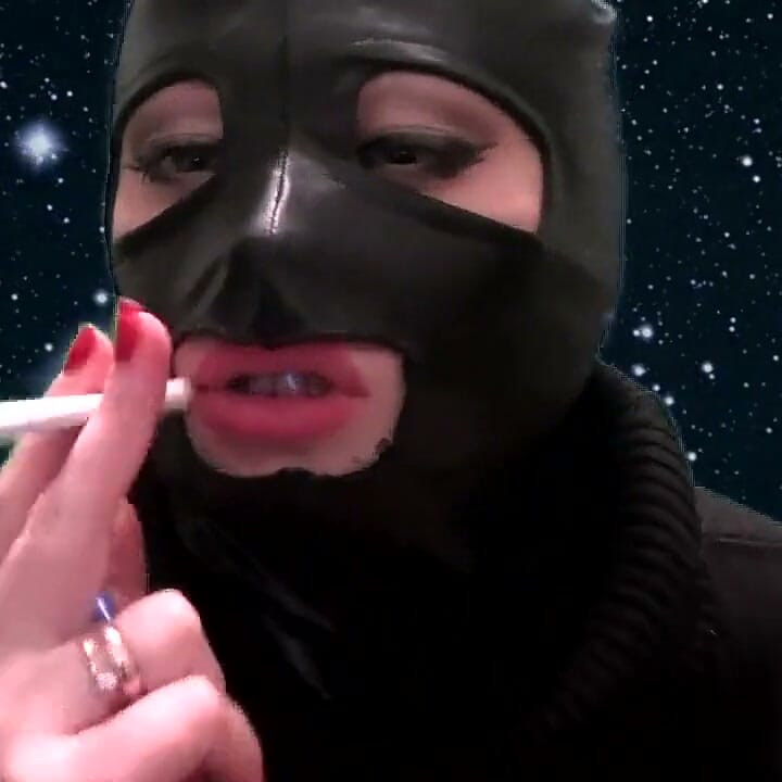 Smoking and teasing you in a latex mask