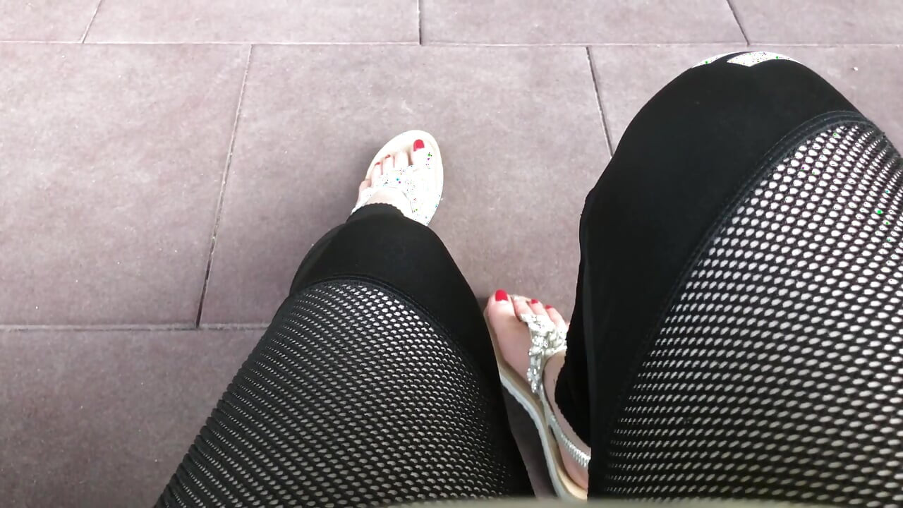 야외에서 빨간 발톱과 발 을 흔들며 괴롭히는 샌들