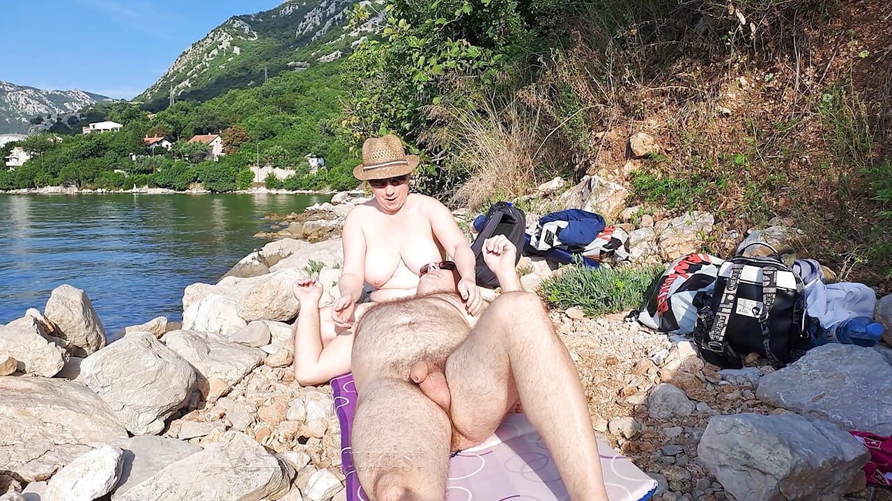 Pareja real da masaje desnudo en playa aislada