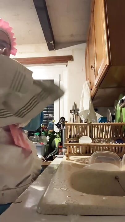 In a blue maid's outfit with pink bows to do the dishes.